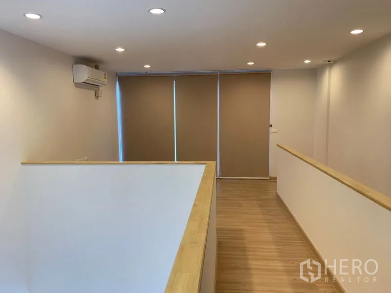 Townhouse for rent in Bang Na, Bangkok - Upper landing with wood floors, air conditioner and blackout blinds