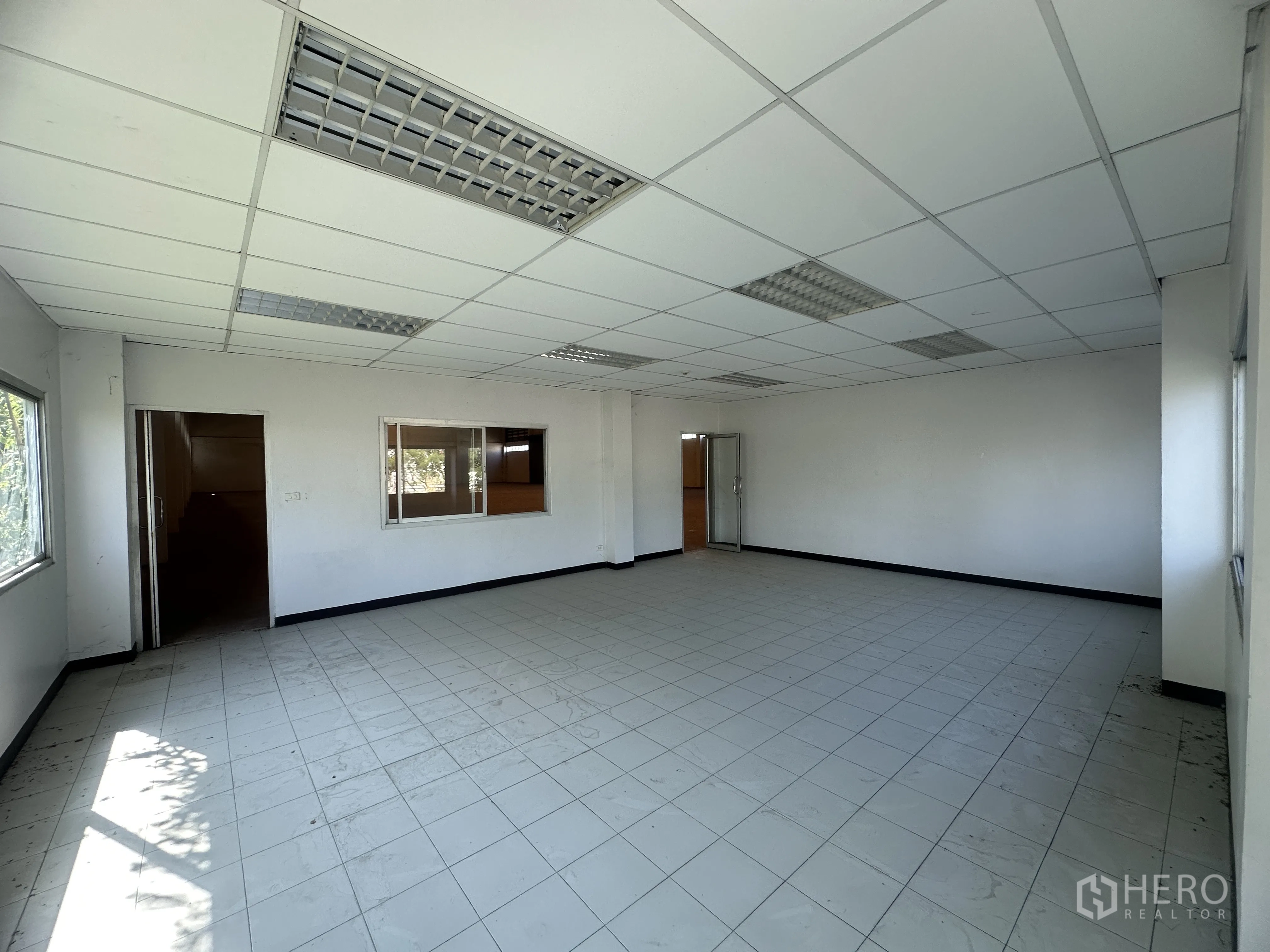 Factory for rent in Bang Pa-in, Phra Nakhon Si Ayutthaya - Bright office room with tiled floor, drop ceiling, fluorescent lighting, and windows.