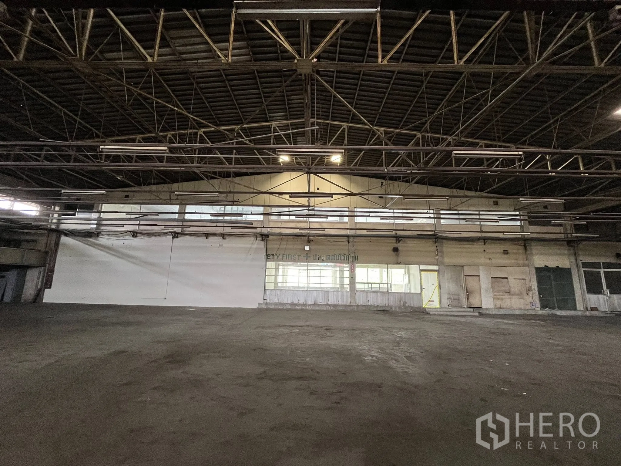 Factory for rent in Phra Pradaeng, Samut Prakan - Large warehouse hall with high steel truss roof and open production floor.