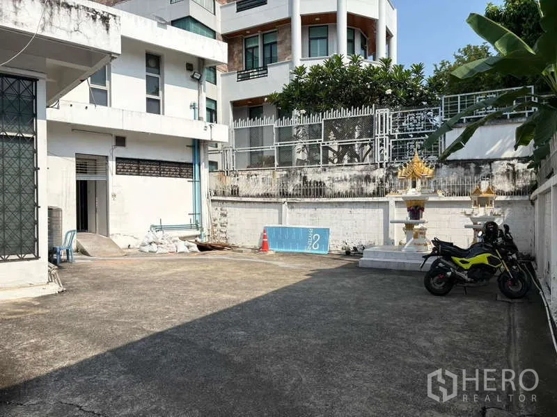 Office Space for rent in Khlong Toei, Bangkok - Outdoor parking court with motorbikes and a spirit house, fits several cars.