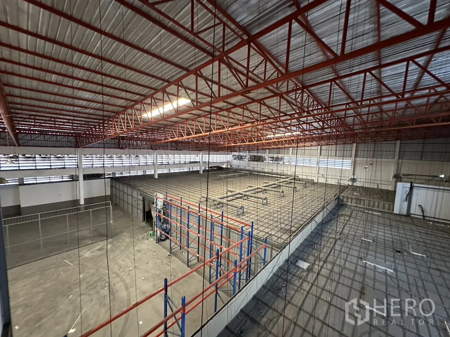 Factory for rent - Overview of racking area and enclosed mezzanine under the steel roof.