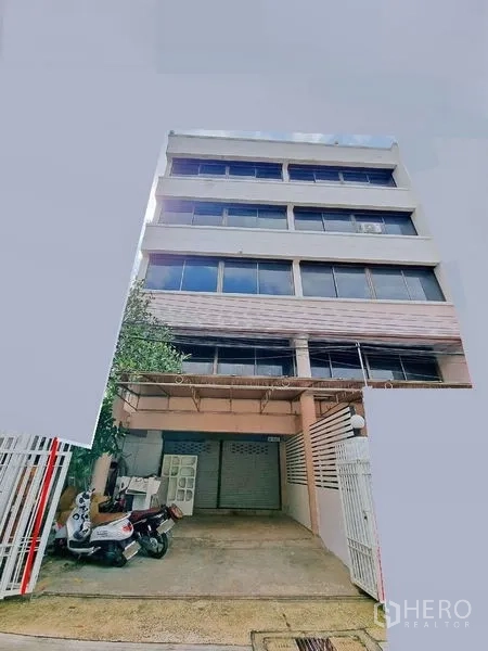 办公空间 出租在Din Daeng, Bangkok - 多层商业建筑外立面，带有院内车道和底层卷帘门。