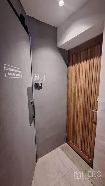 Retail Space for rent in Watthana, Bangkok - Back hallway with a staff-only door and restroom signage in a minimalist grey finish.