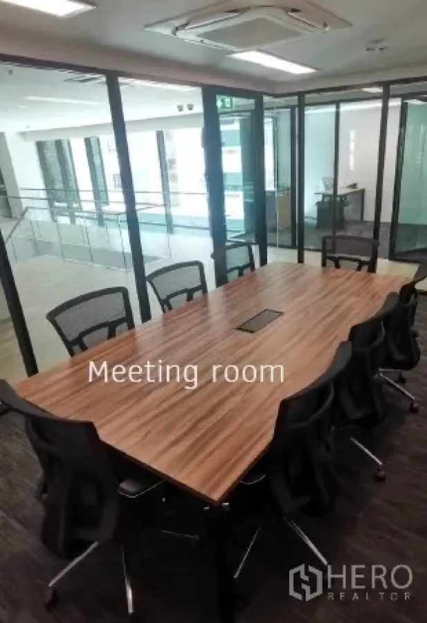 Office Space for rent in Khlong Toei, Bangkok - Glass-partition meeting room with a long wooden conference table, multiple chairs and ceiling air-conditioning.