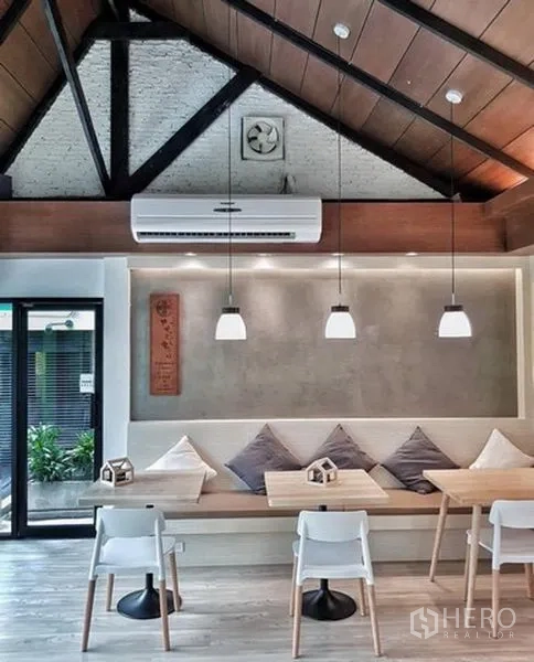 Shophouse for rent in Bang Rak, Bangkok - Cafe seating area with vaulted ceiling, pendant lights, built-in bench seating and air conditioning inside a Bangkok shophouse.