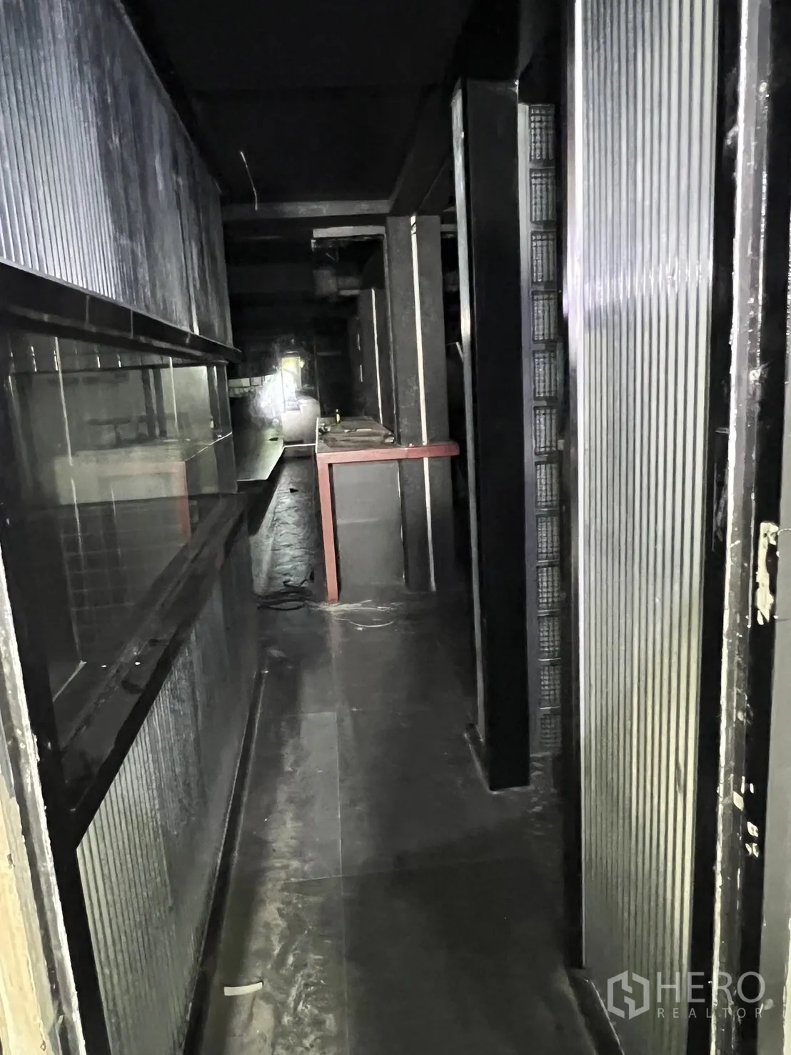 店屋 出租 - 狭长服务通道，玻璃与波纹金属面板。