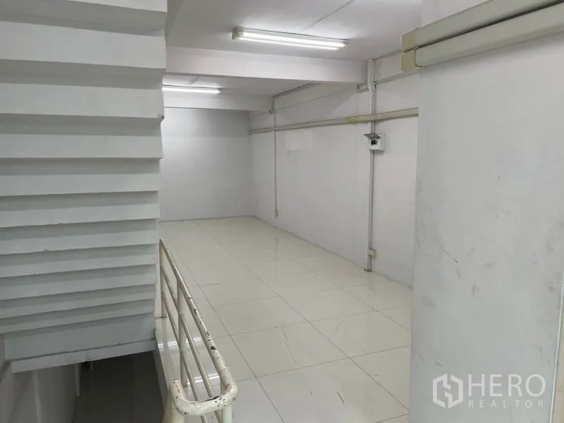 Shophouse for rent in Bang Rak, Bangkok - Long open floor near the stair landing with exposed conduits and tiled flooring.