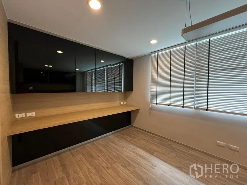 Home Office for rent in Bueng Kum, Bangkok - Work room with long built-in desk and glossy black cabinets.
