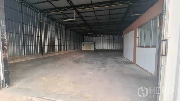 Warehouse for rent in Bang Kapi, Bangkok - Open-plan warehouse interior showing a steel truss roof and smooth concrete floor.