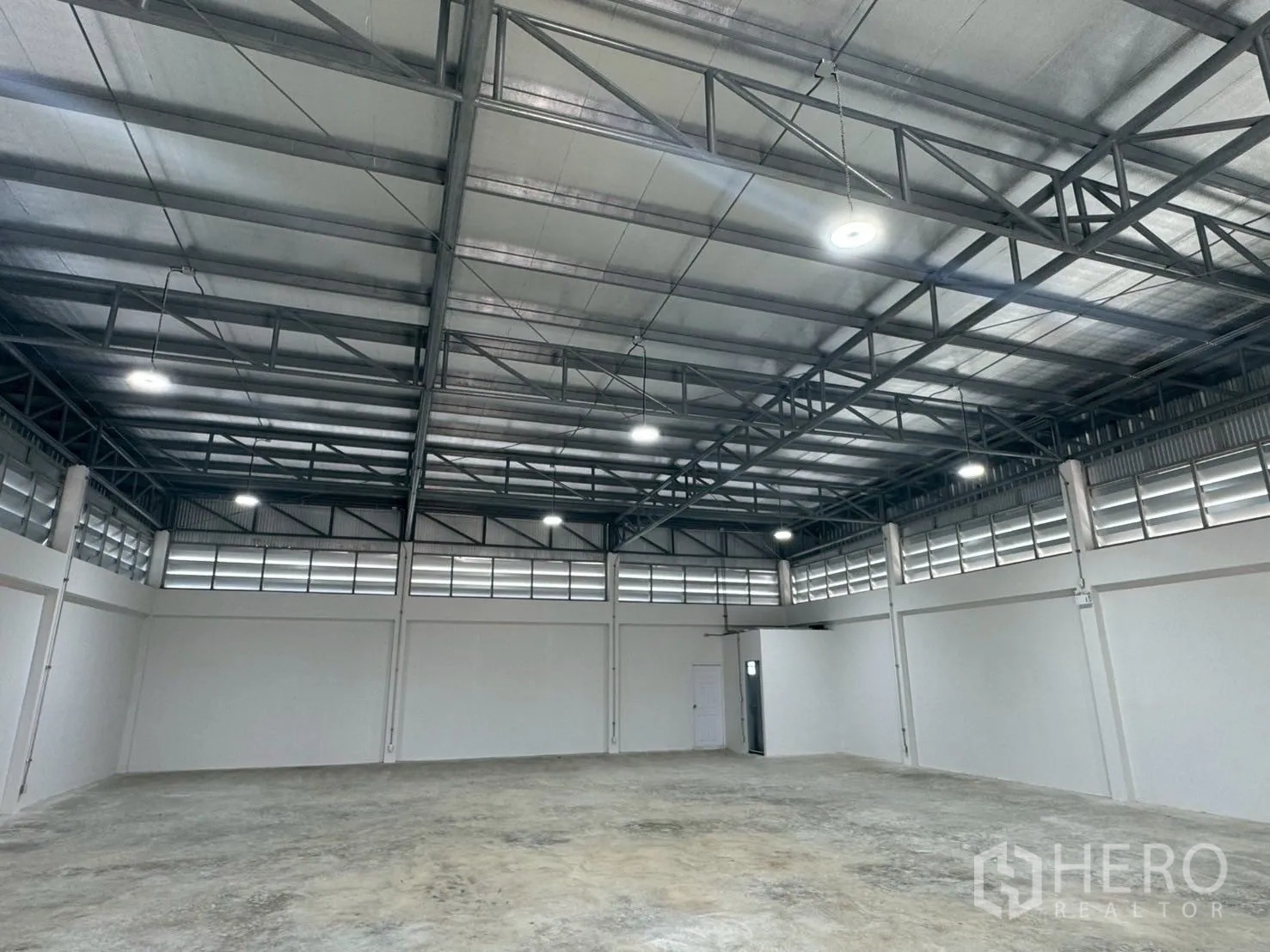 Warehouse for rent or sale in Nong Chok, Bangkok - Open-plan warehouse floor showing high ceiling, ventilation louvers and bright LED lighting.