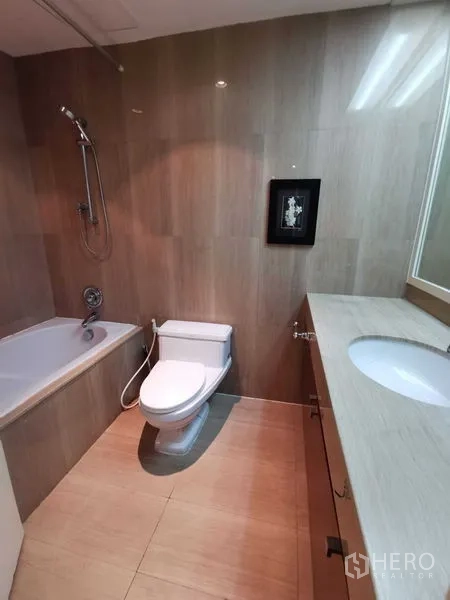 Condominium for rent in Pathum Wan, Bangkok - Bathroom with bathtub, shower, vanity counter, and tiled walls.