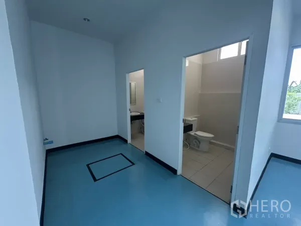 Factory for rent in Bang Phli, Samut Prakan - Small corridor with two doors leading to separate restrooms and blue flooring.