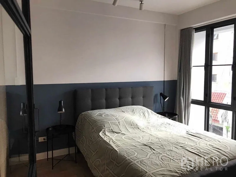 Townhouse for rent or sale in Khlong Toei, Bangkok - Bedroom with tufted headboard, bedside lamps and large windows with curtains.