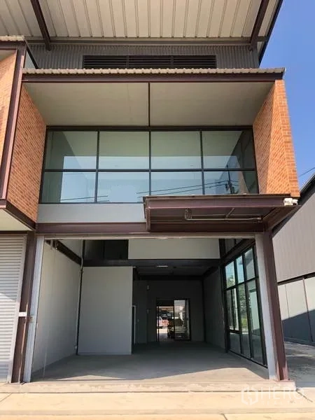 Warehouse for rent in Bang Phli, Samut Prakan - Front elevation showing full-height glazing and open loading bay beneath the balcony.