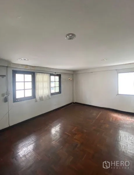 Retail Space for rent in Bang Rak, Bangkok - Bright room with parquet wood flooring, recessed ceiling lights, and two windows with sheer curtains.
