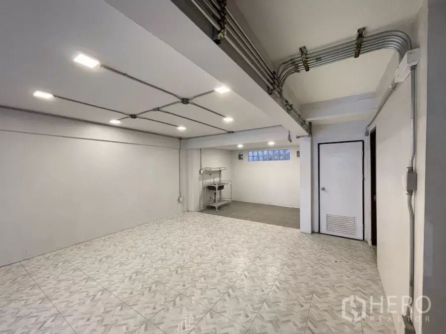 Home Office for rent in Khlong Toei, Bangkok - Bright ground-floor workspace with patterned tiles, exposed conduit ceiling and recessed lighting.