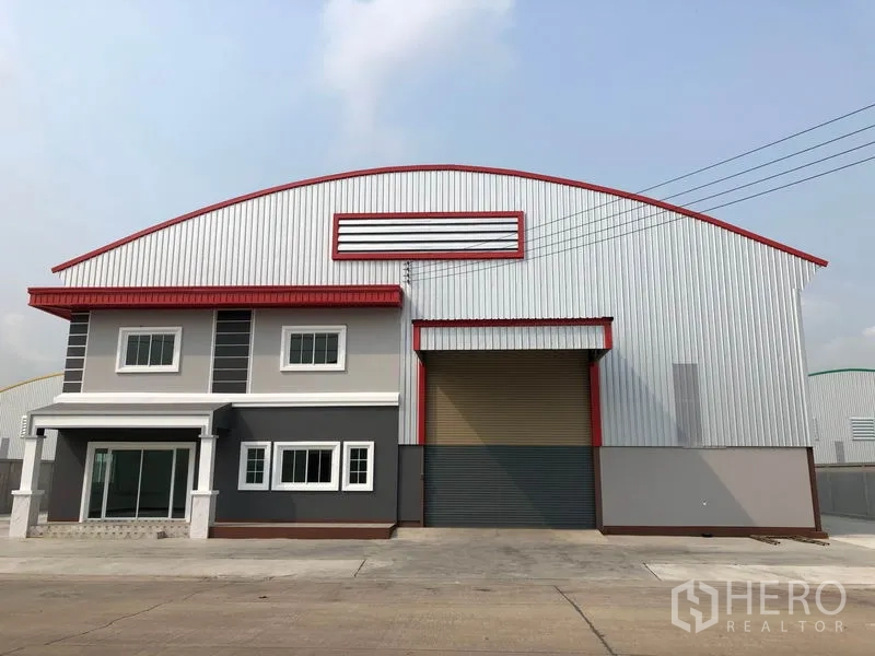Factory for rent or sale in Bang Len, Nakhon Pathom - Front elevation of factory with sliding glass entry and large roller door beside.