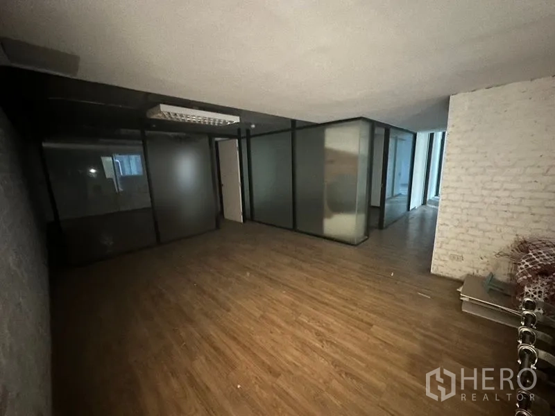 办公空间 出租在Khlong Toei, Bangkok - 开放式办公区，木地板、磨砂玻璃墙与白色砖纹特色墙。