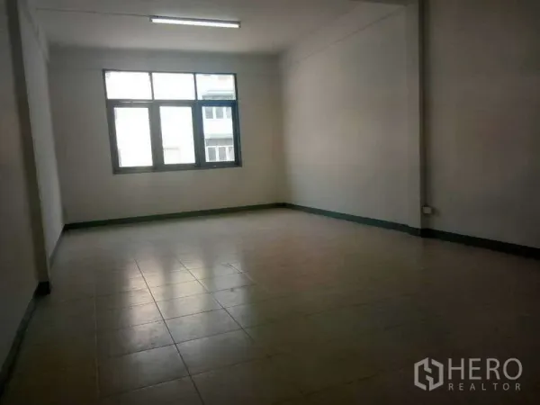 Shophouse for rent in Bang Na, Bangkok - Spacious upper-floor room with large window and tiled floor suitable for office use.