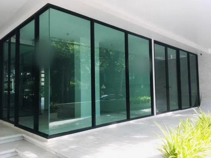 Retail Space for rent in Khlong Toei, Bangkok - Corner retail unit with floor-to-ceiling green-tinted glass facade and a covered walkway in Bangkok.