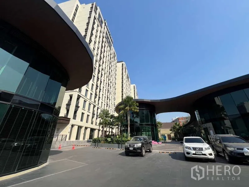 Retail Space for rent in Khlong Toei, Bangkok - Parking area in front of a modern mixed-use complex with surrounding high-rise buildings.