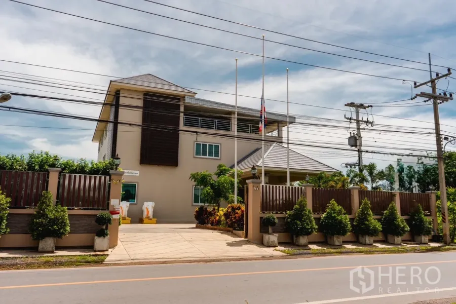 Factory for sale in Khlong Luang, Pathum Thani - Gated modern three-storey factory and office building viewed from the main road.