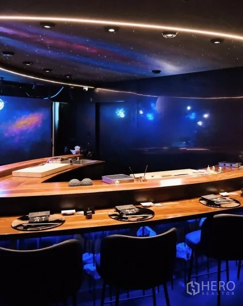 Retail Space for rent in Watthana, Bangkok - Curved wooden counter with bar seating under starry ceiling and blue ambient lighting.