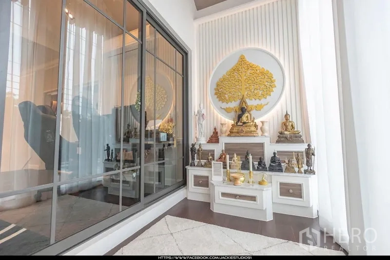 บ้าน ขายในPak Kret, Nonthaburi - ห้องพระโปร่งสว่าง พร้อมหิ้งบูชาบิวท์อินและผนังลายต้นโพธิ์สีทอง ข้างพาร์ทิชันกระจกบานใหญ่