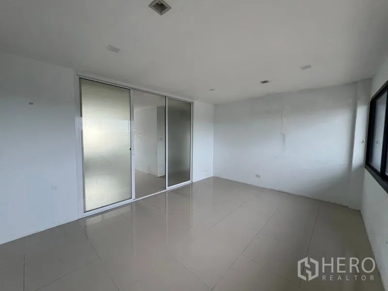 Warehouse for rent in Bang Phli, Samut Prakan - Office with frosted sliding glass doors and a side window above a clean tiled floor.