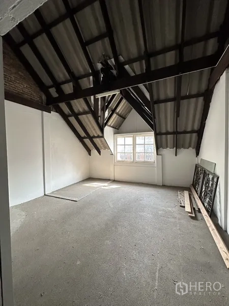 Retail Space for rent in Watthana, Bangkok - Loft room with pitched ceiling, visible rafters, and front window.