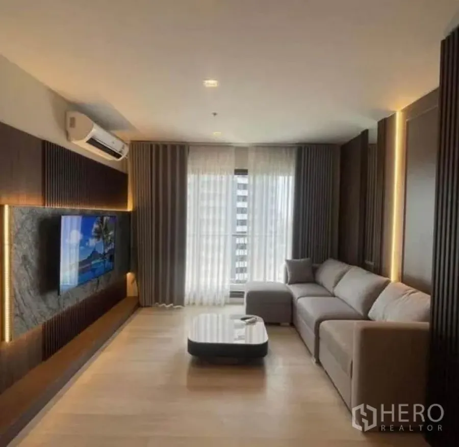 Condominium for rent or sale - Contemporary living room with sofa, coffee table and sheer curtains.