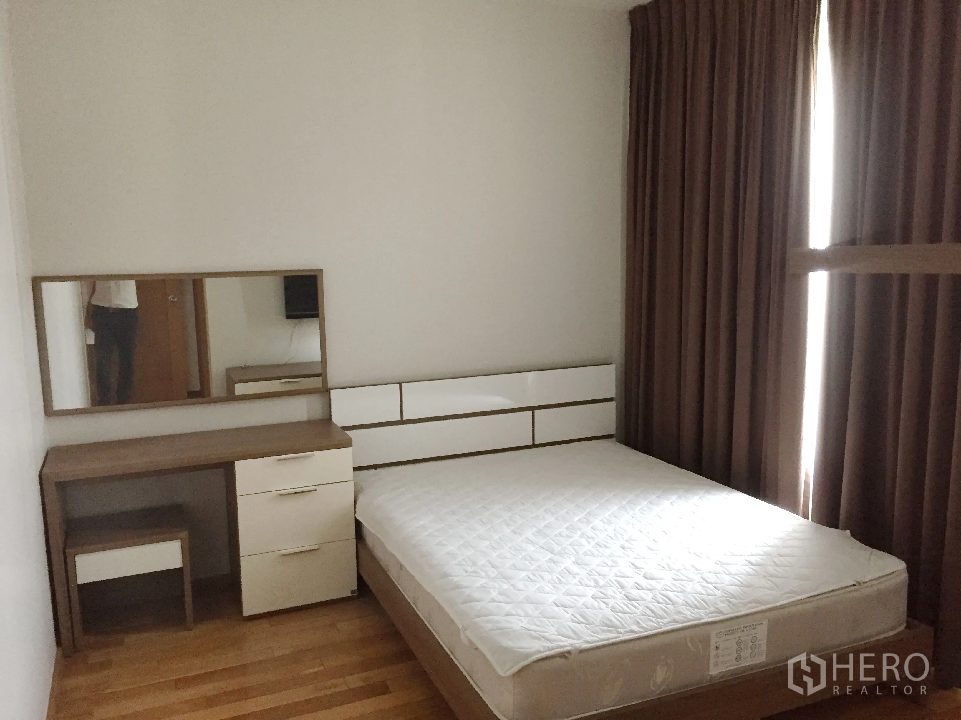 Condominium for rent in Khlong Toei, Bangkok - Bright bedroom with queen-size bed, dressing table, built-in storage, and blackout curtains.