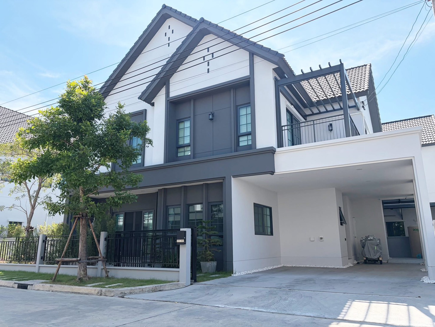 Detached House for rent in Bang Phli, Samut Prakan - Contemporary two-storey detached house exterior with carport, balcony and fenced garden.