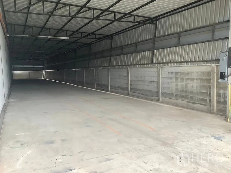 Factory for rent in Ban Phaeo, Samut Sakhon - Side view of long sheltered loading corridor with metal cladding.
