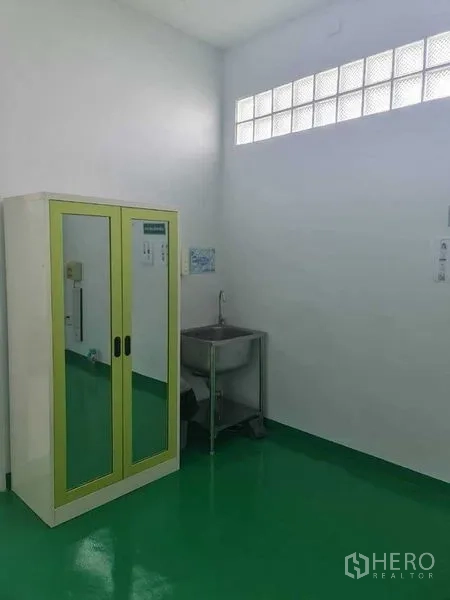 Factory for sale in Bang Pa-in, Phra Nakhon Si Ayutthaya - Utility corner with a sink and mirrored cabinet beneath a glass-block window.