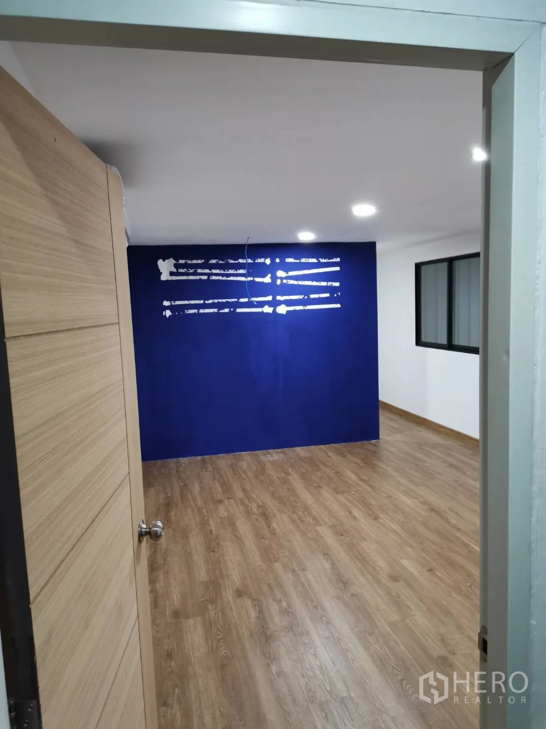 Warehouse for rent in Suan Luang, Bangkok - View through a doorway into the office showing open workspace and a feature wall.