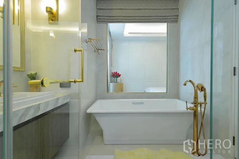 Detached House for rent or sale in Watthana, Bangkok - Luxury bathroom with soaking tub, gold fixtures and a separate glass shower.
