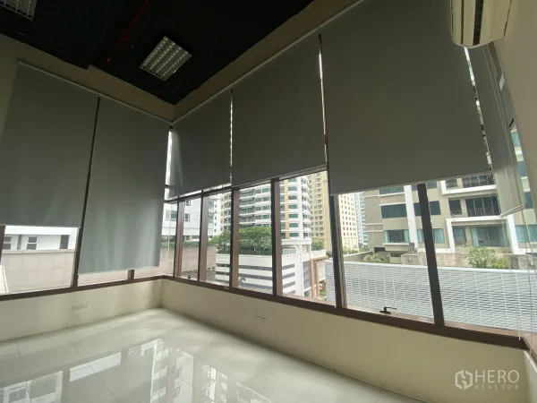 Office Space for rent in Khlong Toei, Bangkok - Corner workspace featuring floor-to-ceiling windows with roller blinds and city views.