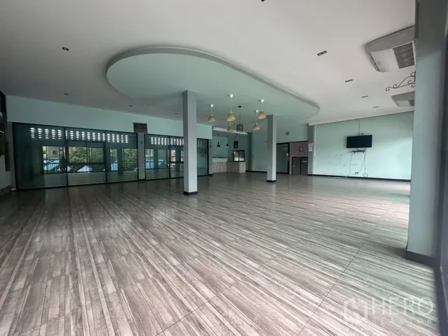 Standalone for rent in Prawet, Bangkok - Spacious open hall with columns, curved ceiling feature and wood-look tile flooring.