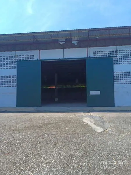 Warehouse for rent in Mueang Rayong, Rayong - Front view of the warehouse with open green sliding doors and a concrete apron.