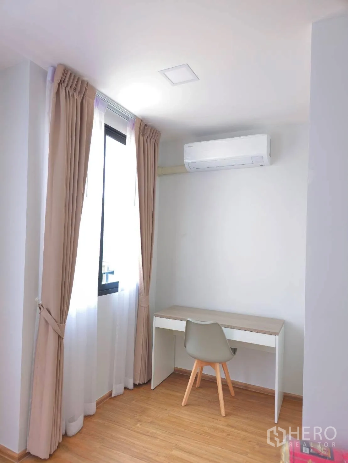 Townhouse for rent in Bang Phli, Samut Prakan - Bright study nook with a desk and chair next to a window and air conditioner.