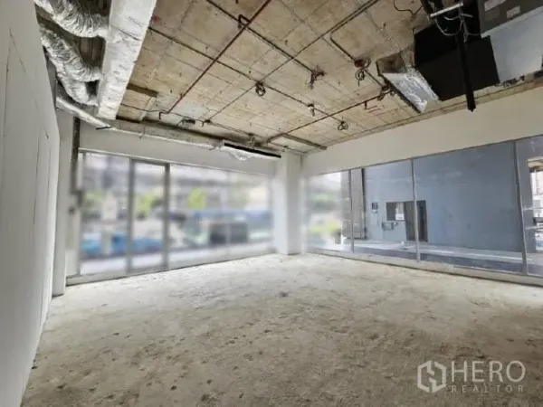 Retail Space for rent - Shell retail interior with exposed ceilings, ducted HVAC, and wraparound windows.