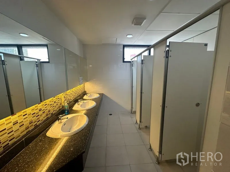 Office Space for rent in Bang Rak, Bangkok - Shared restroom with granite counter, three basins and cubicle stalls.