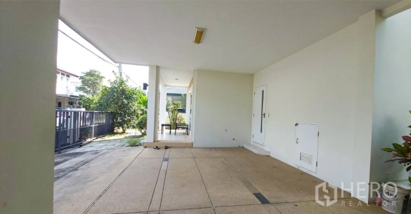 Detached House for sale in Bang Kapi, Bangkok - Covered carport and front porch next to a small garden walkway.