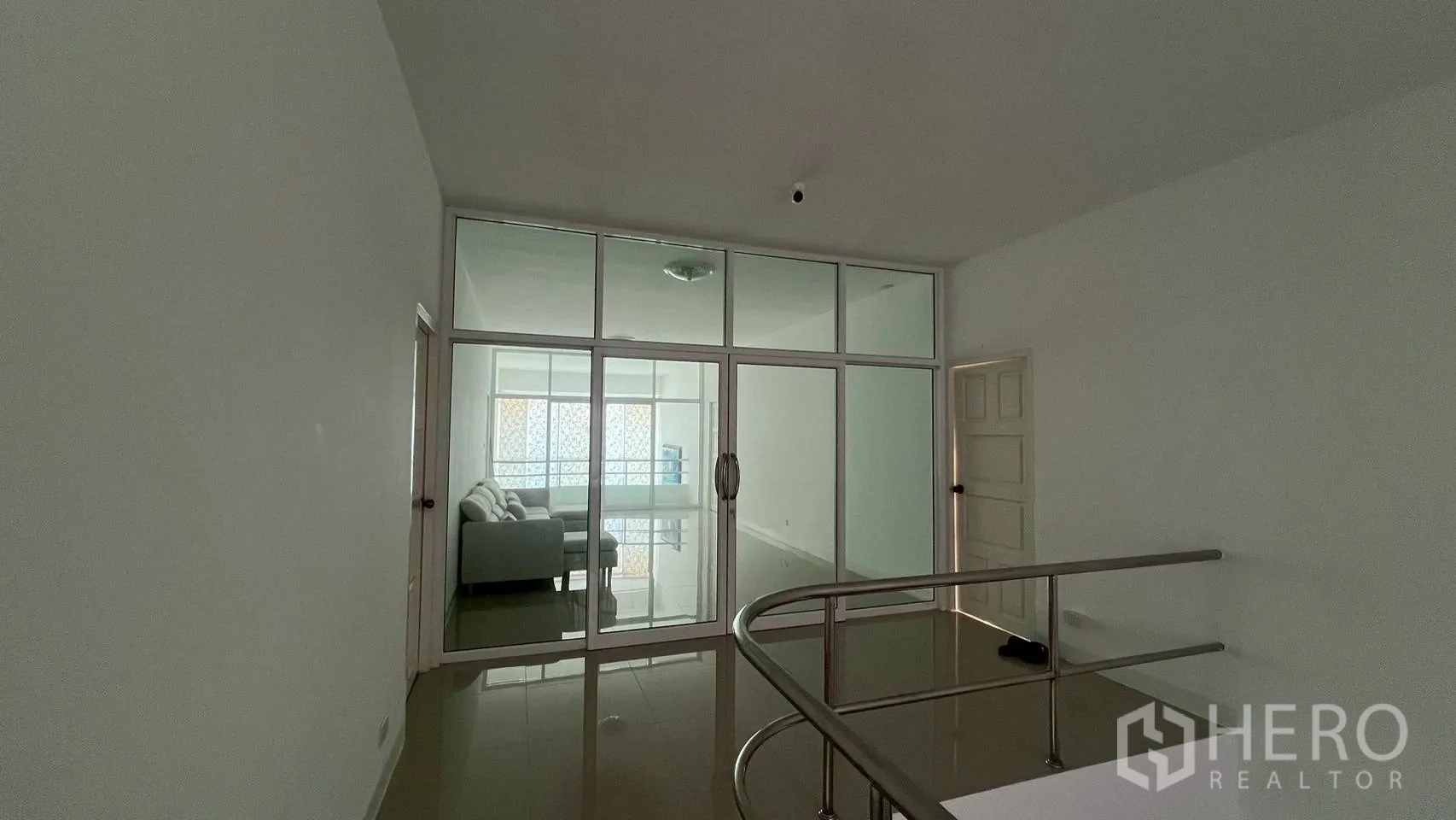 Home Office for rent in Wang Thonglang, Bangkok - Upper-floor hallway with sliding glass doors revealing a lounge area.