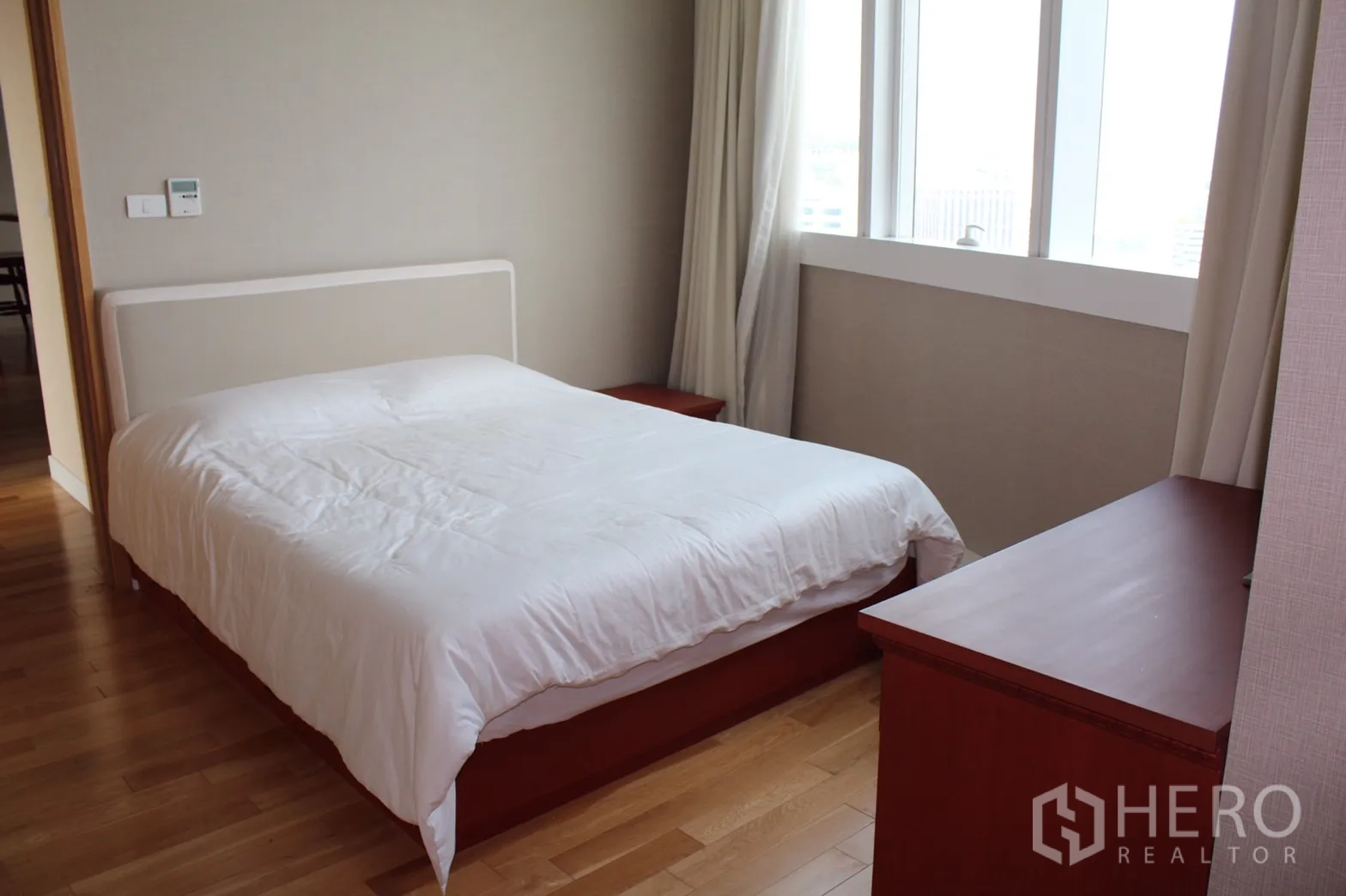 Condominium for rent in Khlong Toei, Bangkok - Second bedroom with double bed, bedside tables, wide windows and light curtains.