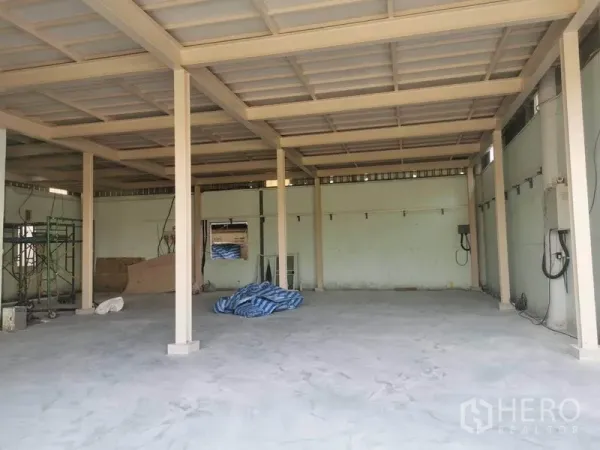 Warehouse for rent in Prawet, Bangkok - Industrial space with high ceiling, concrete slab floor, and wall-mounted utilities for operations.