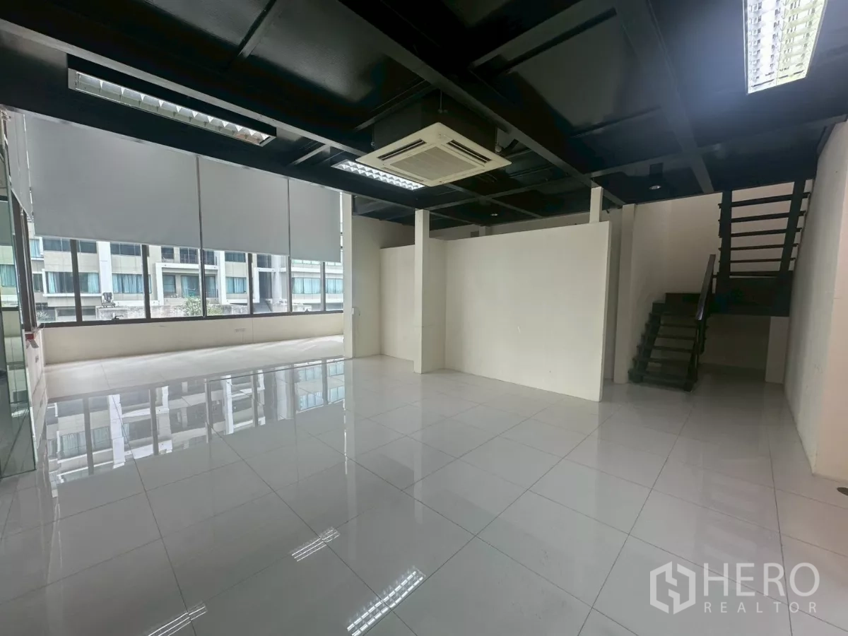 Office Space for rent in Khlong Toei, Bangkok - Spacious work area with staircase to the mezzanine and roller blinds on wide windows.