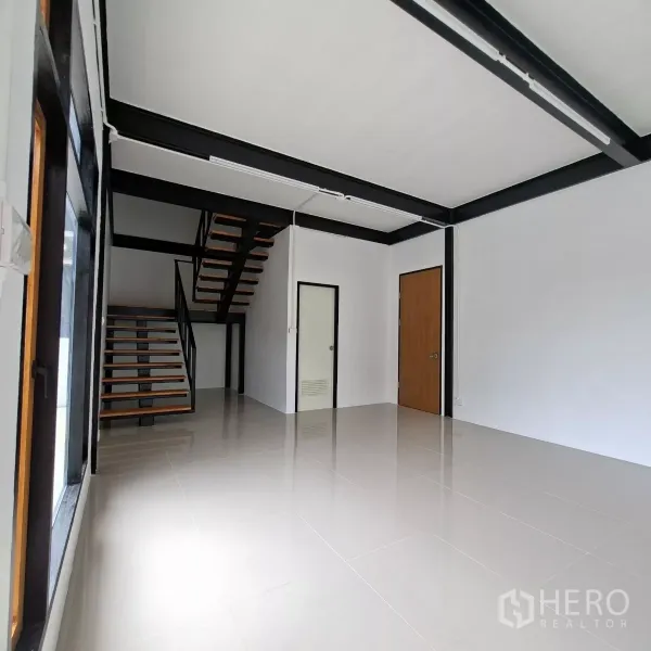 Warehouse for rent in Lam Luk Ka, Pathum Thani - Bright ground-floor office with glossy tile flooring, steel staircase and internal doors ready for meeting room or reception.