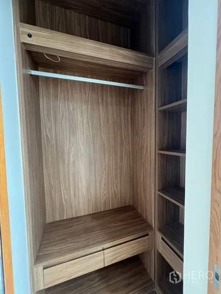 Condominium for sale - Built-in wooden walk-in wardrobe with shelves, drawers and hanging rail.